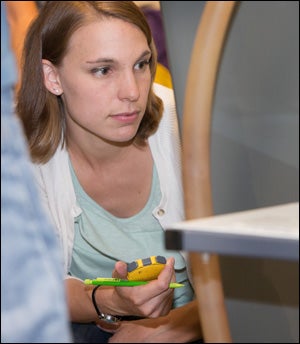 Engineering student Lauren Bridgers uses a volumetric bench to measure flow rates, and she is shown recording the data from the tests. 