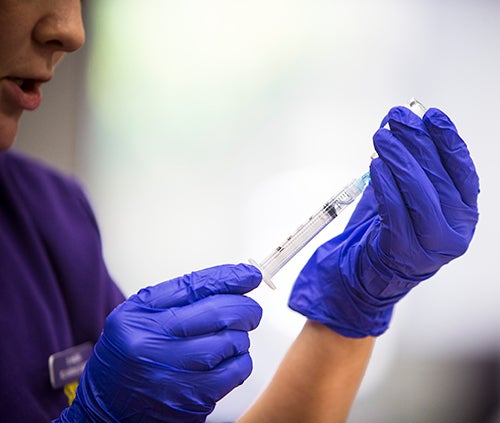 An ECU College of Nursing student prepares flu shots during an on-campus flu vaccine clinic. (Photo by Cliff Hollis)