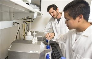 Grad student Rick Alleman, left, and medical student Alvin Tsang work together in the research lab.