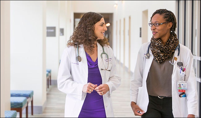 ECU family medicine physician Dr. Susan Keen and Brody medical student Demetria Watford chat following a procedure on a patient.