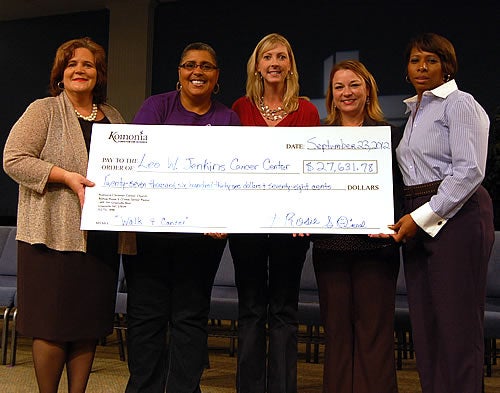 From left, Michele Miller, Leo W. Jenkins Cancer Center administrator; Bishop Rosie S. O’neal of Koinonia Christian Center; Ginny Jackson, a cancer center social workers; Fredia Butts, cancer center business manager; and Hollie Wooten, coordinator of the Walk 4 Cancer and a cancer center employee, hold a ceremonial check representing a donation to cancer center assistance funds.