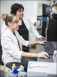 ECU researcher Tonya Zeczycki and second-year doctoral student Stephanie Adams study enzyme kinetics.