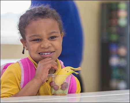 A child at the Farmville Boys and Girls Club enjoys healthy snacks provided by Snack RX, a program offered by nutrition science students in ECU's College of Human Ecology. The program reaches more than 350 children in weekly programs at all Pitt County Boys and Girls Clubs.