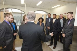 Dr. Craig Slotke, director of general dentistry for the Robeson County Community Service Learning Center, gives a tour to ECU dental students and parents before the ceremony.