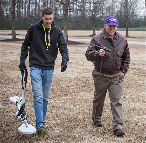 Geology graduate student Adam Trevisan, left, and environmental health specialist Charlie Humphrey carry tools to a site for research.