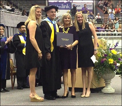 Lee's family and Dean White are shown at the college commencement ceremony.