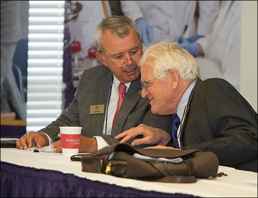 UNC Board of Governors members Bob Rippy, left, and Thomas J. Harrelson talk before the start of the governance committee meeting. (Photo by Cliff Hollis)