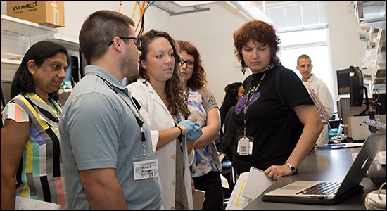 ECU doctoral student Lauren Reese, center in white lab coat, presents on Mito Ca2 retention capacity during the ECU conference.