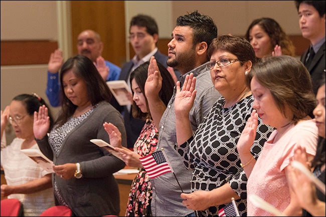 Pictured below, new U.S. citizens take their pledge during a ceremony held at ECU Aug. 14.