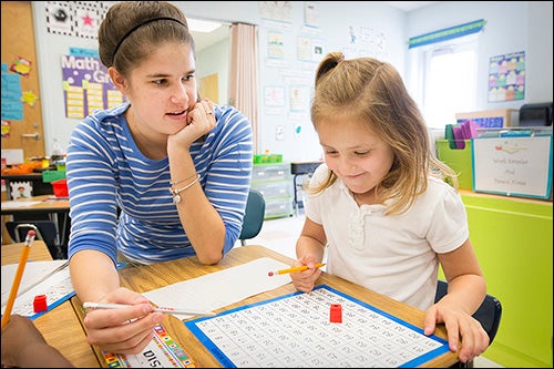 ECU education graduate Lisa Thomas goes over a lesson with a kindergarten student. Thomas was an intern in ECU's co-teaching model, which paired her with a veteran teacher.