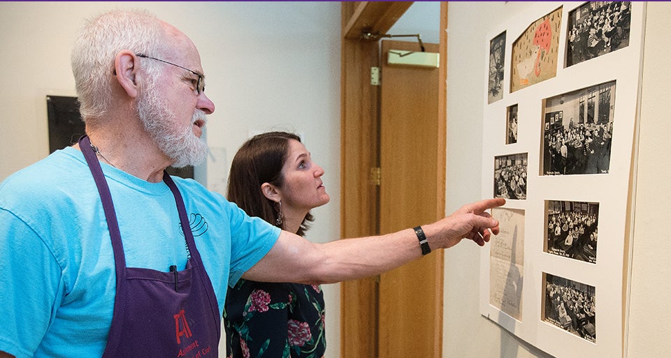 ECU artist Bob Ebendorf and Mary Savig, curator of manuscripts at the Smithsonian archives, view Ebendorf's artwork on display at the Greenville Museum of Art.