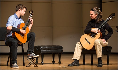 ECU master’s student and graduate assistant Jacob Brown, left, and Elina Chekan, classical guitar teacher, practice techniques on the guitar.