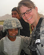 Senior Chief Petty Officer Pat Frede poses with an Afghan child during her most recent deployment to the country. Contributed photo