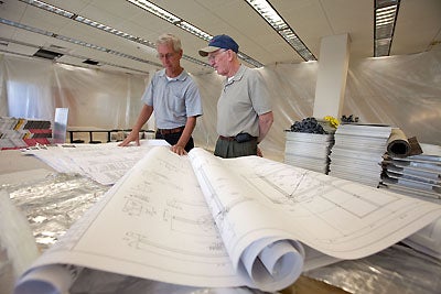 Ed King, left, with O'Neal Construction and Gerry Gable, ECU project management, look over renovation plans on the third floor of Laupus Library. Photo by Cliff Hollis.