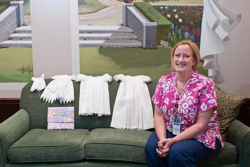 Ann Kubanda shows some of the bereavement gowns and a memory envelope she has made for her patients and parents. Contributed photo by John Lynch, Memorial Hermann Healthcare System.