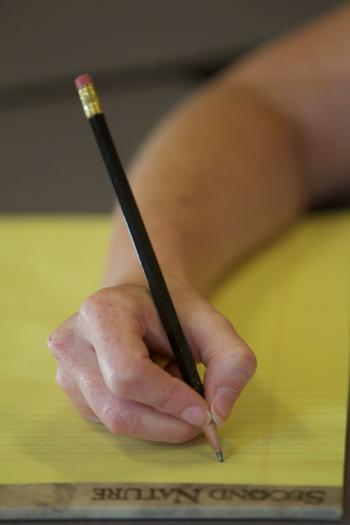 Denise Donica demonstrates the correct way to hold a pencil using the tripod grasp. "When you're writing, you're really just using the first three fingers," Donica said. (Photo by Cliff Hollis)