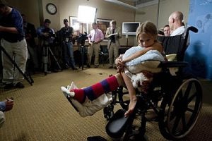 Lucy clutches a stuffed dolphin during Tuesday's news conference.