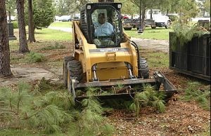 Ivan Armstrong of the health sciences grounds department uses a loader to pick up debris on the medical school campus Tuesday, Aug. 30. Photo by Doug Boyd