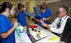 From left, students Hanna Zombek, Kimberly Vinson, Jonathan Weisner listen as Dr. Linc Conn, associate professor and chair of general dentistry, explains a procedure.