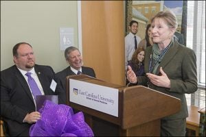 Lynda Kinnane, director of the Toe River Health District, speaks at the opening of the Spruce Pine dental community service learning center. Senator Ralph Hise, left, and ECU Chancellor Steve Ballard are shown in the background.