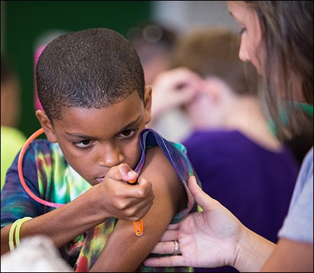 Malachi Wilkins checks his blood sugar with help from Priscilla Spivey, an ECU nurse specialist.