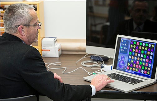 Center director Carmen Russoniello demonstrates the video game that helps veterans recover from wartime experiences.