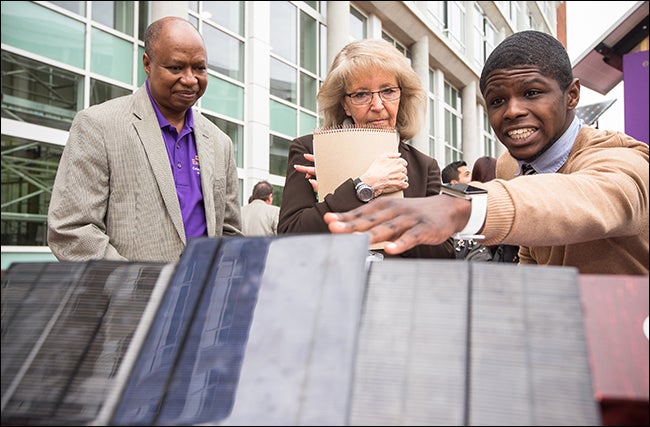 Left to right, Technology Systems Chair T.J. Mohammed, College of Engineering and Technology Administrative Support Specialist Karen Wagner and student Aaron Grant discuss a solar charger designed by ECU students.