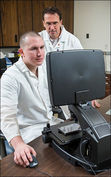 ECU physiology professor Dr. David Tulis, standing, is assisted in his research by doctoral candidate Andrew Holt. Tulis will apply private funding toward his investigation of how blood vessels are damaged by diabetes.