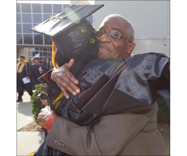 ECU graduate Marquerite Latham hugs her neighbor rev. Elbert Coburn after the ceremony is done. (Photos by Cliff Hollis)