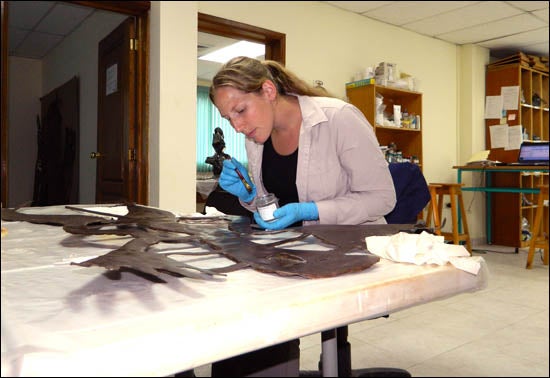 Susanne Grieve is shown working on one of the Haitian sculptures created from flattened steel drums and that was damaged during the earthquake. During this part of her volunteer work, she worked in a former United Nations program building in Port-au-Prince. (Contributed photo)