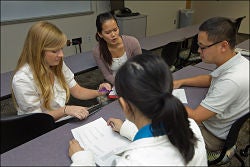 Facing left to right, speech language pathology graduate students Ashley Wittenauer and Jenny Tang lead language academy students in an exercise in the articulation and phonology lab. Photos by Cliff Hollis, ECU News Services.