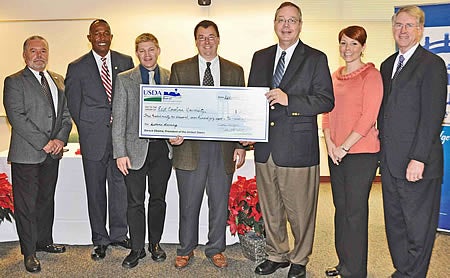 From left, Billy Barker, field representative for Rep. Mike McIntyre; Randall Gore, state director of USDA Rural Development; Phillip Allen, director of informatics operations at the dental school; Dr. Todd Watkins, assistant dean for dental education and informatics at the dental school; Dallas Tonsager, undersecretary for USDA Rural Development; Donnarie Hales, grants coordinator at the school; and Dr. Greg Chadwick, interim dean of the dental school, show off the symbolic check representing the grant of nearly $373,000 ECU received for telemedicine programs. Contributed photo