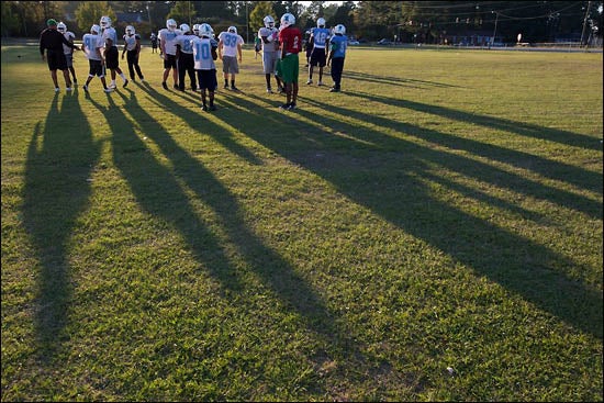 Athletic trainers from ECU help manage safety of Pitt County high school athletes through a partnership between the university and the Pitt County school system. When not assigned to cover a game, the athletic trainers will be on hand at team practice like the afternoon practice at J.H. Rose High School pictured above. (Photo by Cliff Hollis).