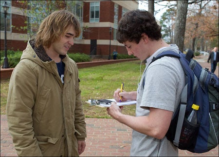 Jonathan Yelverton encourages students to sign a petition protesting recommended tuition increases Friday outside the Sonic Plaza. Yelverton is a junior and a history education major who organized the petition drive.