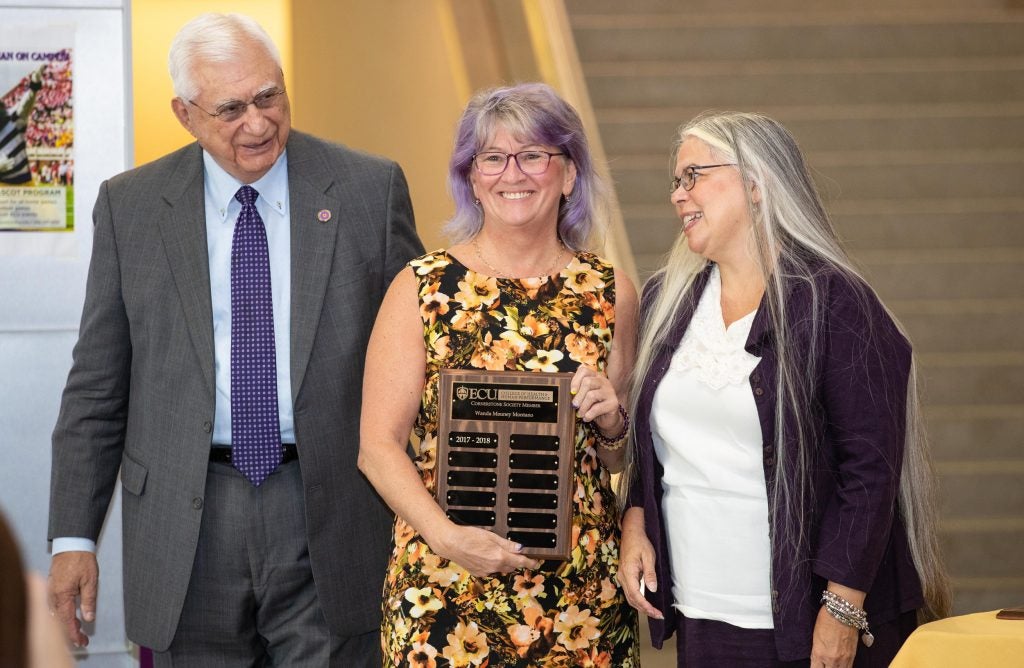 Charlotte resident and vice-chair of the HHP Advancement Council Wanda Montano, center, receives her Cornerstone Society plaque from Dean Anisa Zvonkovic and Development Specialist Don Leggett on Sept. 28 in the Smith-Williams Center. 