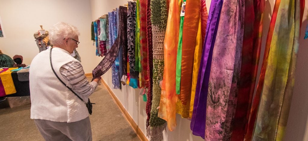 A customer looks at textiles at last year’s ECU School of Art and Design annual Holiday Art Sale. 