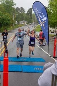 Faculty members Vera Tabakova and Brad Rodgers finish the ECU Alumni Road Race on Saturday. 