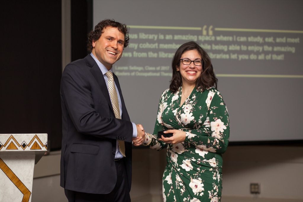 <em>Chair of the Friends of Laupus Library Dr. John Papalas presented book author Dr. Marina Boushra, clinical assistant professor in Brody’s Department of Emergency Medicine, with a Laupus bronze medallion during a Nov. 14 celebration held at The Martinsborough at the Jefferson Blount Harvey Building in Greenville. (Photo contributed by Michelle Messer)