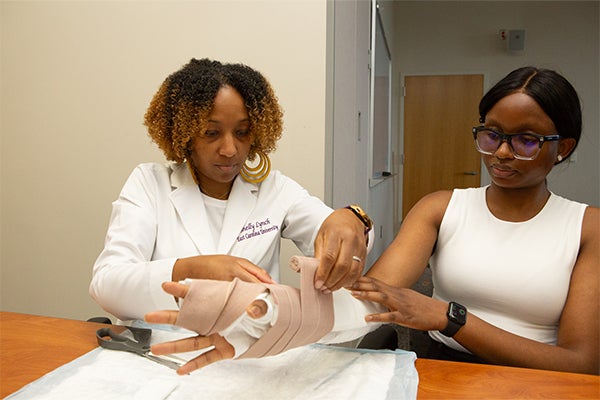 Two women practicing medical procedures