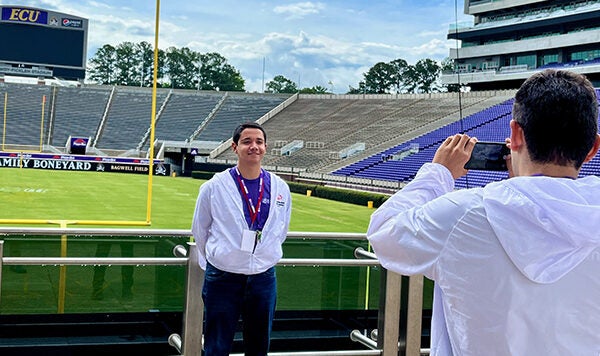 Angel Castañeda Vargas smiles for a photo at Dowdy-Ficklen Stadium. (Photo by Ronnie Woodward)