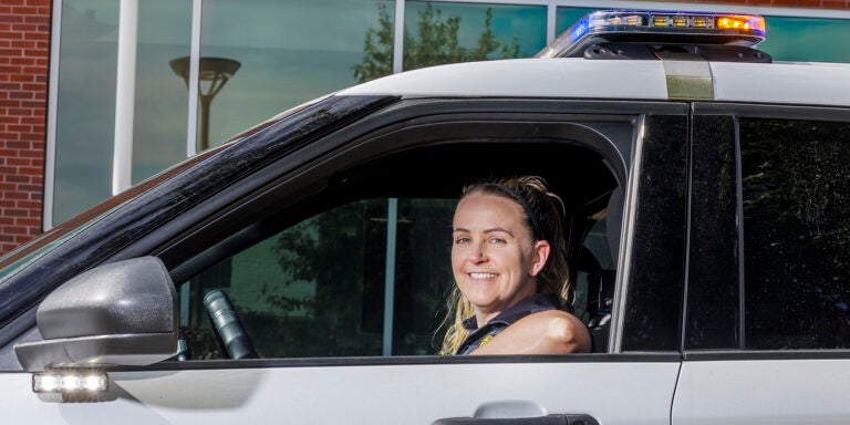 A campus police officer stops her patrol car in front of East Carolina University’s student center.