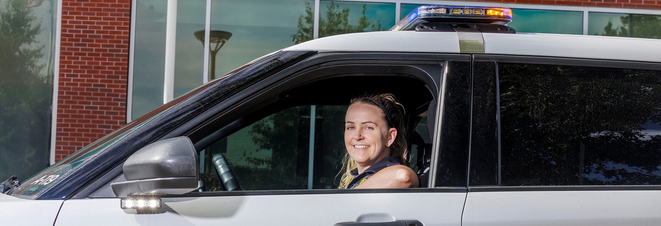 A campus police officer stops her patrol car in front of East Carolina University’s student center.