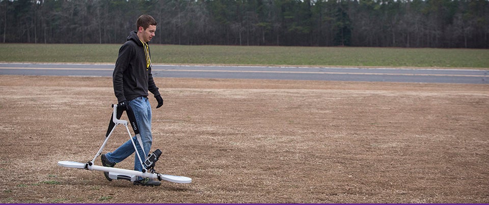 ECU geology graduate student Adam Trevisan heads to a research site carrying an electromagnetic induction profiler, used to trace water impurities so ECU researchers can follow where groundwater is flowing underground. The work is part of a collaborative effort to examine water contaminants that may migrate from home septic systems. (Photos by Cliff Hollis)