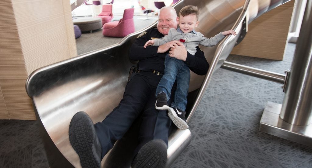 ECU Police Chief Jon Barnwell and his son Grayson slide down the slide at the ECU Health Sciences Student Center following Barnwell’s swearing-in ceremony.