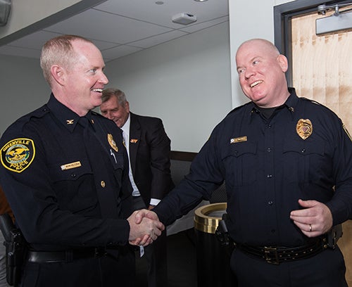 Greenville Police Chief Mark Holtzman, left, congratulates ECU Police Chief Jon Barnwell following Barnwell’s swearing-in ceremony Friday, Dec. 15.
