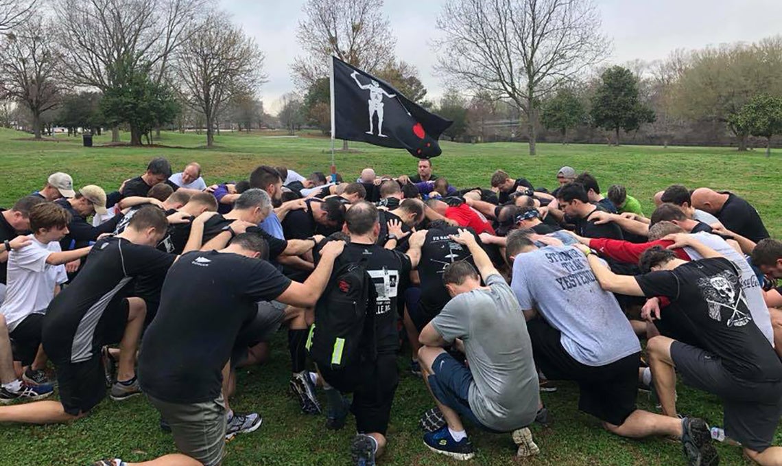 The F3 ENC workout group that Nelson Cooper helped start in Greenville in a moment of prayer.