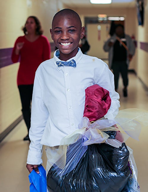 An ECU Lab School fourth grader leaves school for the holidays on Wednesday, Dec. 20, with his gift of winter clothes donated by the ECU community.