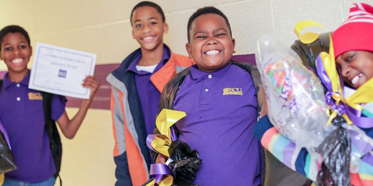ECU Lab School scholars show off their surprise holiday gifts inside the Lab School at South Greenville Elementary School.