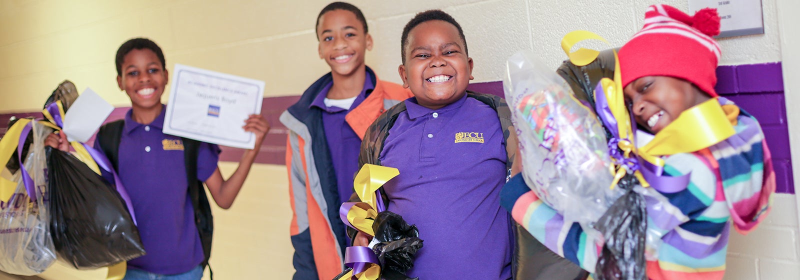 ECU Lab School scholars show off their surprise holiday gifts inside the Lab School at South Greenville Elementary School.