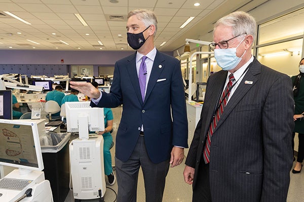 ECU Chancellor Dr. Philip Rogers, left, visits the School of Dental Medicine’s Preclinical Technique Lab, where he talks with students and Dr. Greg Chadwick, the school’s dean.